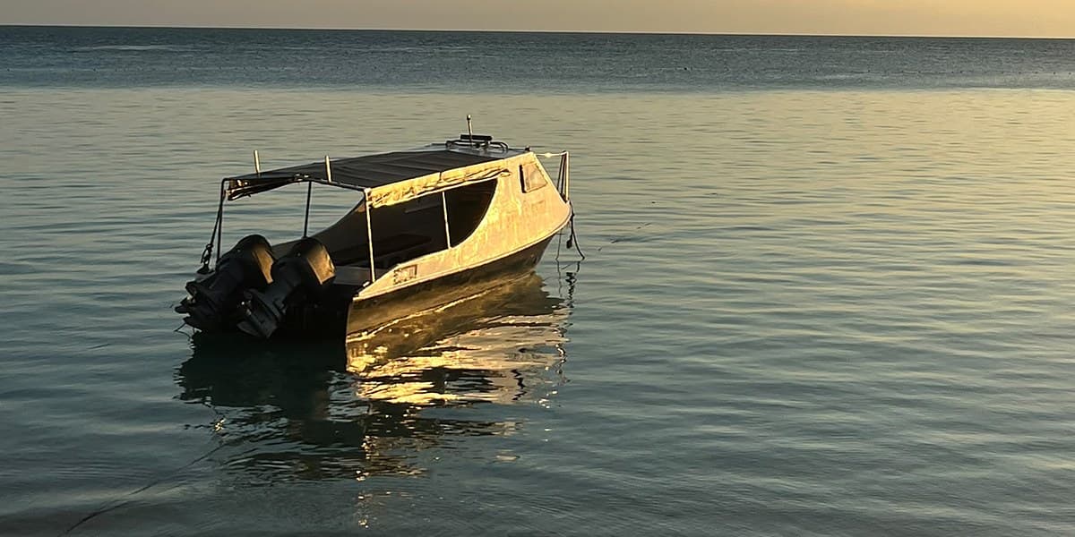 A small boat on calm water at sunset in Borneo